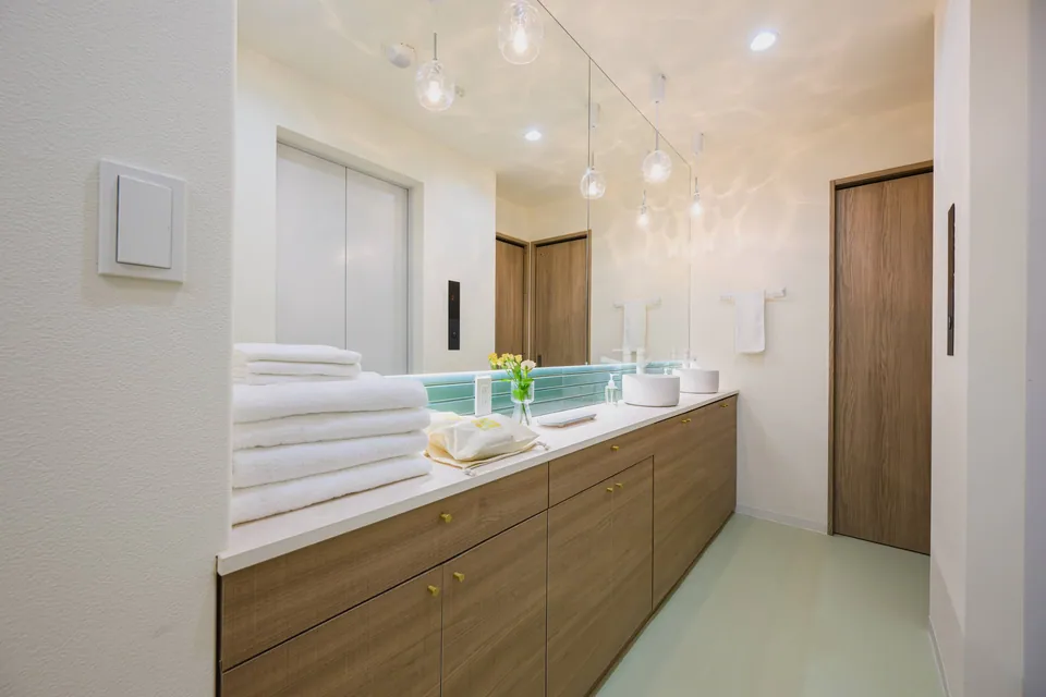 The twin washbasins and wooden storage at ARiA STAY HATSUDAI
