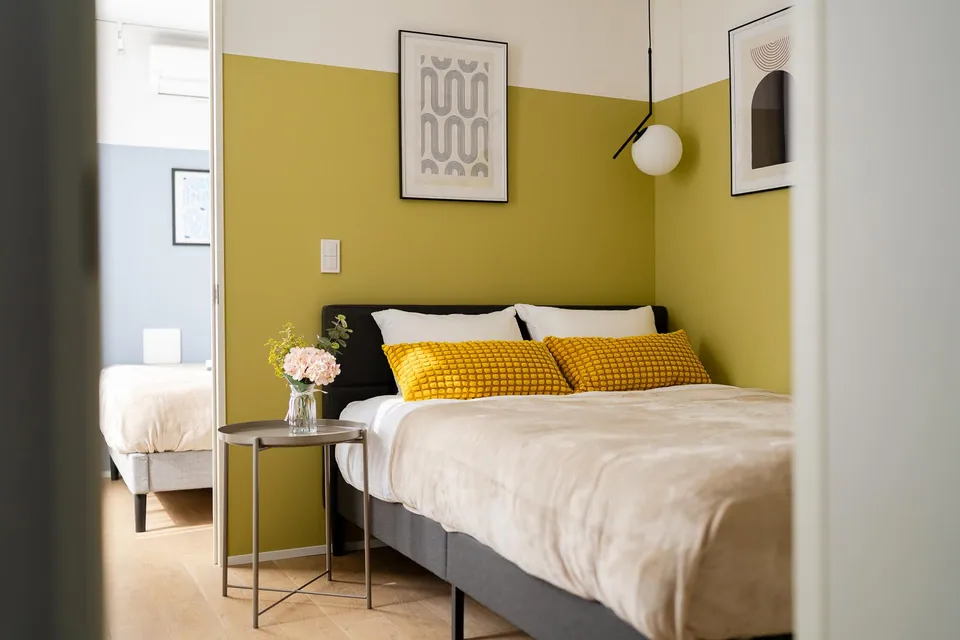SB01 bedroom with an olive wall and yellow cushions