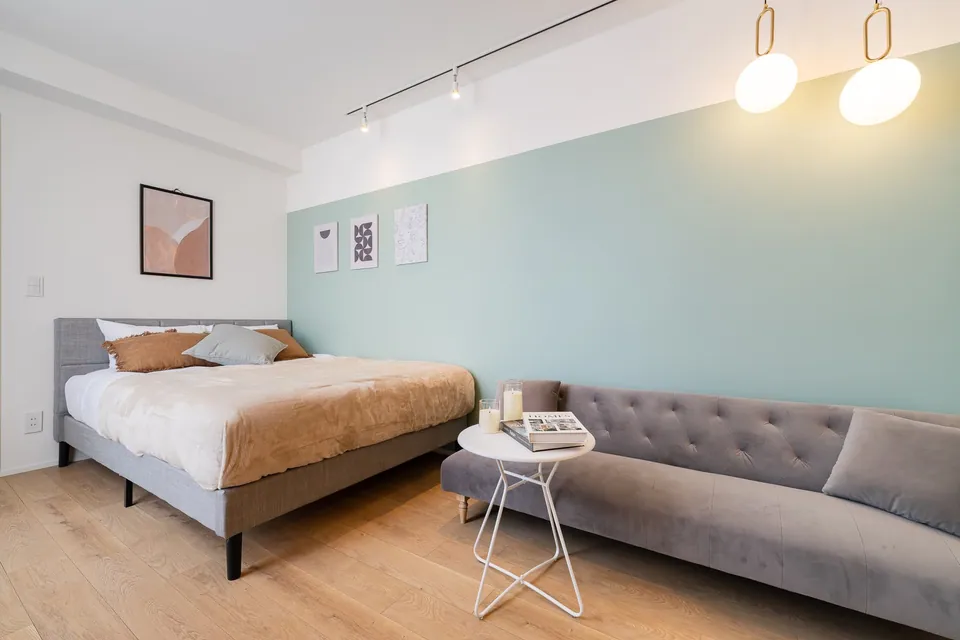 SB02 bedroom with a pale green wall and grey sofa