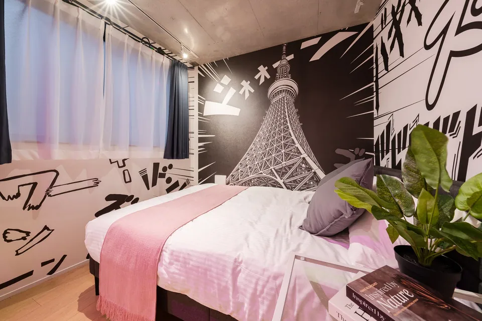 The bed in SB11, with monochrome artwork and pink bedding