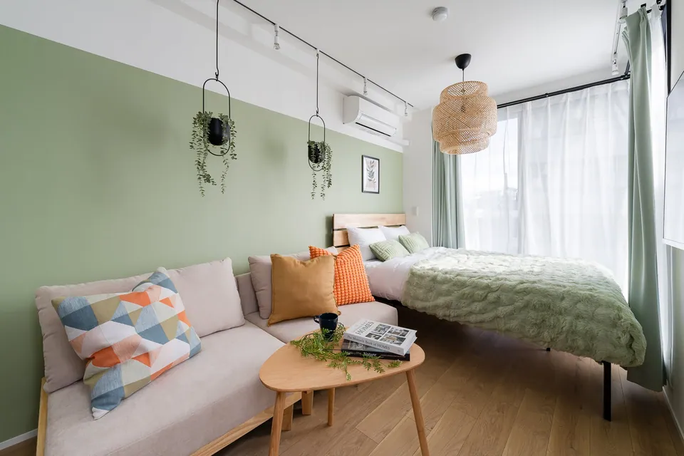 The SB3C studio, with sage green walls and a rattan light