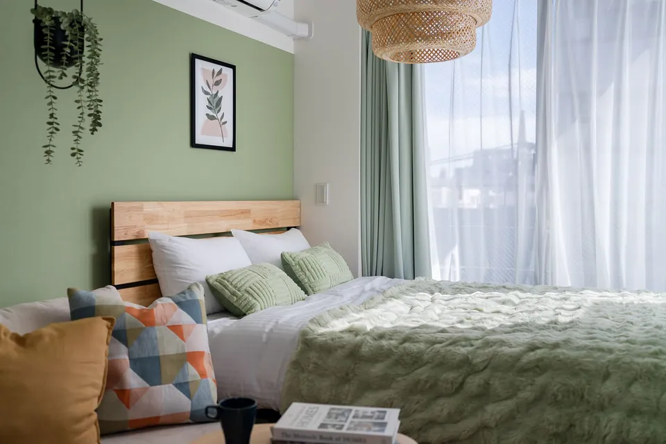 The bed beside a large window and rattan light in SB3C