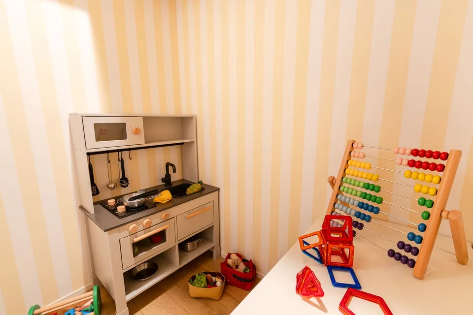 The play corner in SB51, with yellow walls and wooden toys