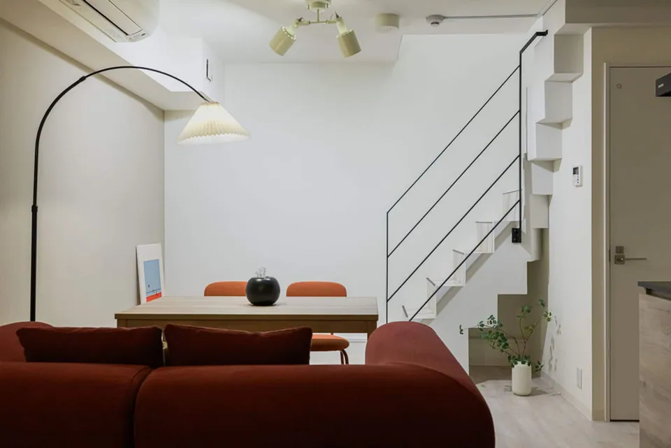 The red sofa, dining area and staircase in Takanawa 101