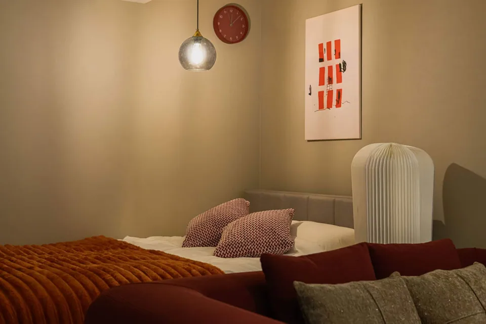 A softly lit sleeping area with red bedding in Takanawa 101