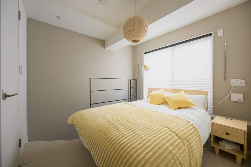 A bedroom in Takanawa 102, with yellow bedding beside the window