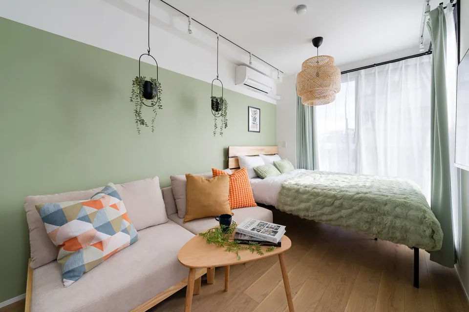SB3C: Sage & rattan. Sage green walls, a rattan light and a softly coloured sofa create a warm, natural setting.