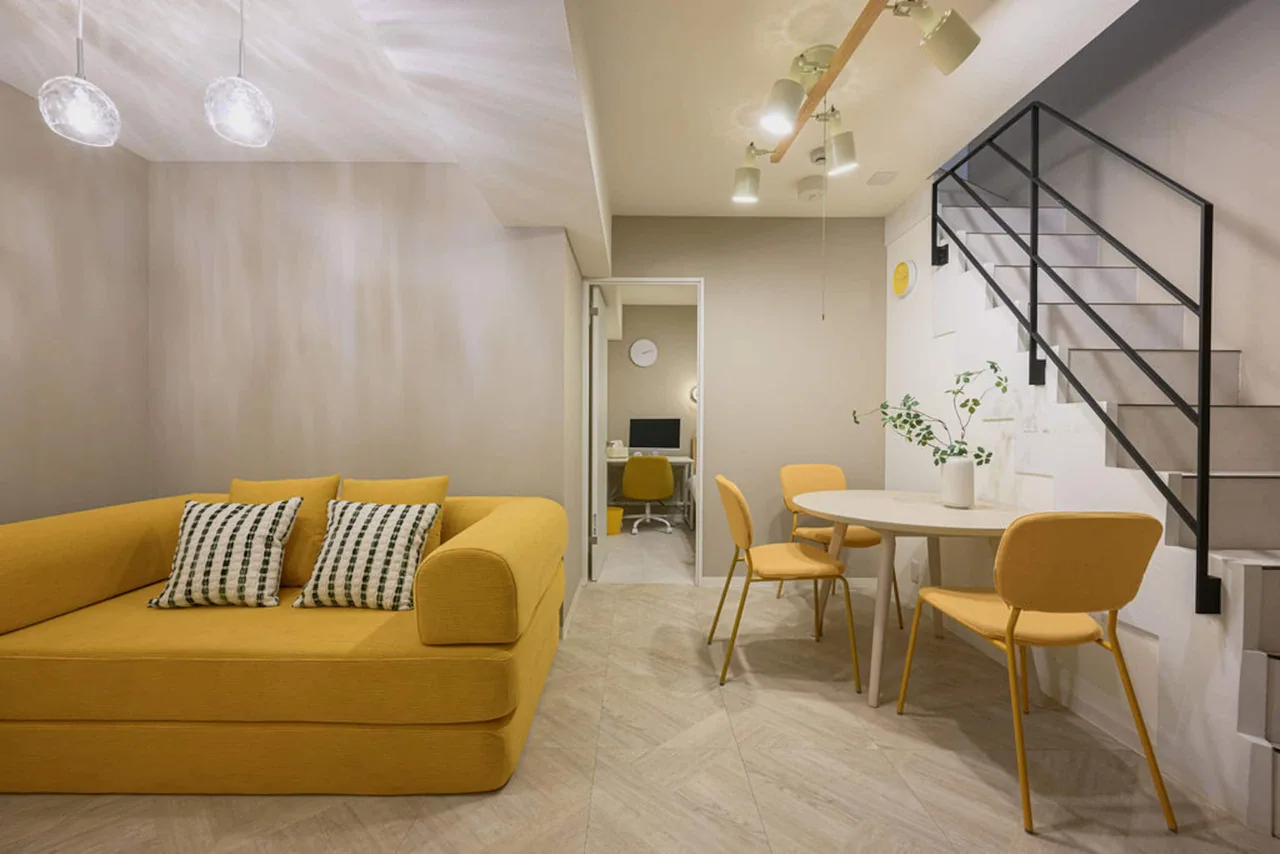 Room 102 at ARiA STAY TAKANAWA, with yellow accents and a living and dining area.